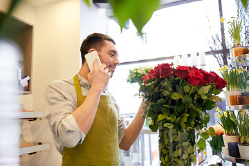 Image showing man with smartphone and red roses at flower shop