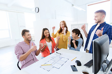 Image showing happy creative team celebrating success at office