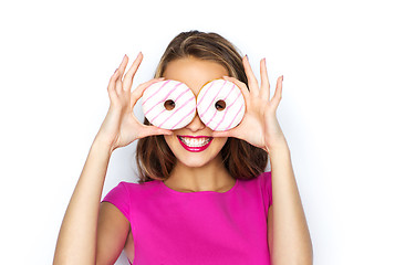 Image showing happy woman or teen girl looking through donuts