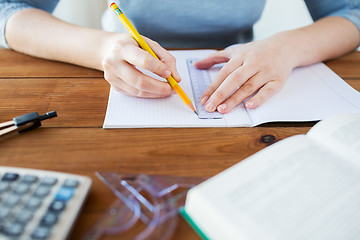 Image showing close up of hands with ruler and pencil drawing 