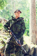 Image showing young soldier or hunter with gun in forest