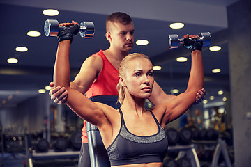 Image showing man and woman with dumbbells in gym