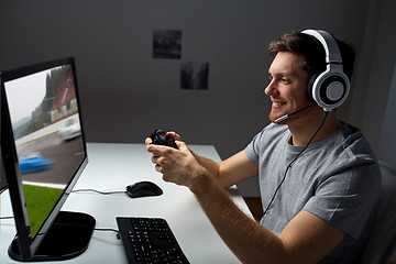 Image showing man in headset playing computer video game at home