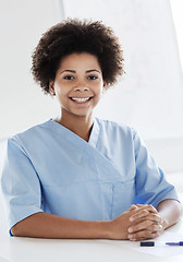 Image showing happy doctor or nurse with clipboard at hospital