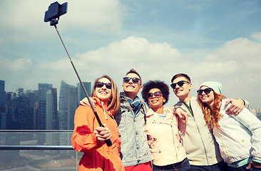 Image showing smiling friends taking selfie with smartphone