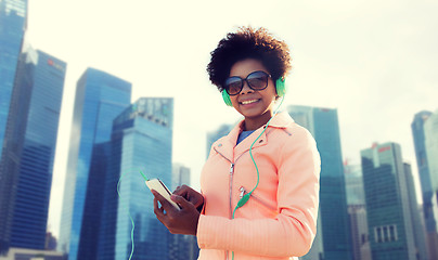 Image showing happy young woman with smartphone and headphones