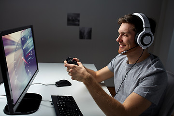 Image showing man in headset playing computer video game at home