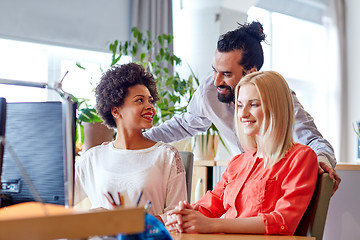 Image showing happy creative team with computer in office