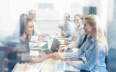 Image showing smiling business people shaking hands in office