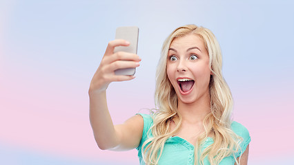 Image showing smiling young woman taking selfie with smartphone