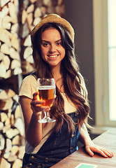 Image showing happy young woman drinking water at bar or pub