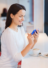 Image showing smiling woman with smartphone and coffee at cafe