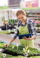 Image showing happy woman with tablet pc in greenhouse