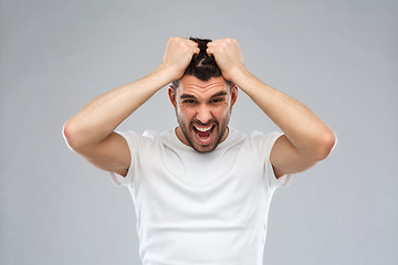 Image showing crazy shouting man in t-shirt over gray background