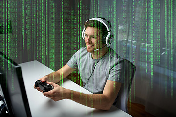 Image showing man in headset playing computer video game at home