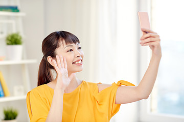 Image showing happy asian woman taking selfie with smartphone