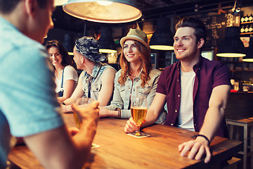 Image showing happy friends drinking beer and talking at bar