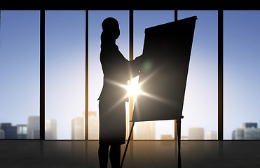 Image showing silhouette of woman with flipboard over office