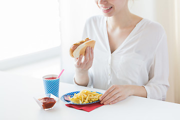 Image showing close up of woman eating hotdog and french fries