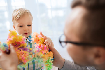 Image showing father and son playing with ball clay at home