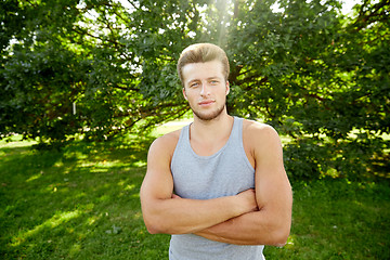 Image showing sporty young man with crossed arms at summer park