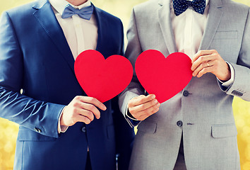 Image showing close up of male gay couple holding red hearts