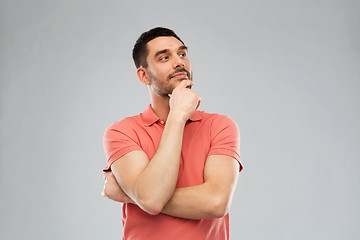 Image showing man in polo t-shirt thinking over gray background