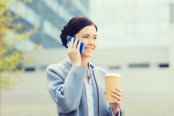 Image showing smiling woman with coffee calling on smartphone