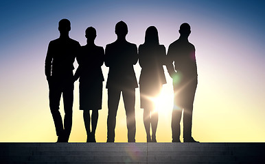 Image showing business people silhouettes on stairs over sun