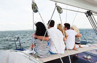 Image showing happy friends sailing and sitting on yacht deck