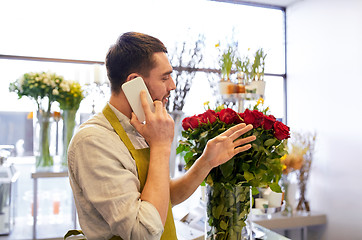 Image showing man with smartphone and red roses at flower shop