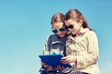 Image showing happy girls with tablet pc computer outdoors