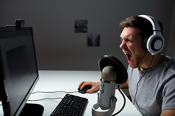 Image showing man in headset playing computer video game at home