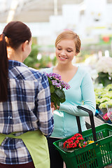 Image showing happy women choosing flowers in greenhouse or shop