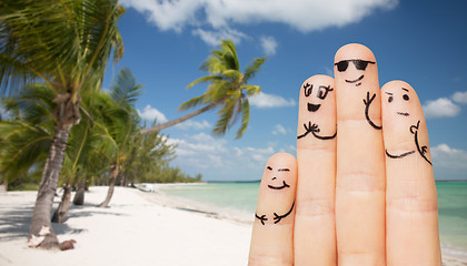 Image showing close up of fingers with smiley faces on beach