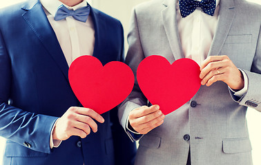 Image showing close up of male gay couple holding red hearts