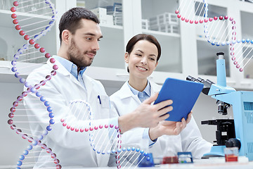 Image showing scientists with tablet pc and microscope in lab