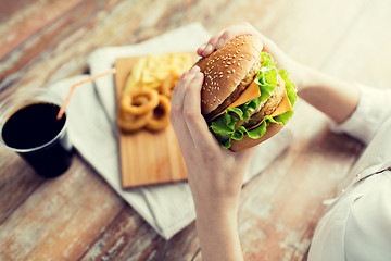 Image showing close up of woman hands holding hamburger