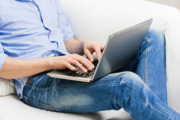 Image showing close up of man typing on laptop computer at home