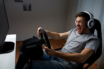 Image showing man playing car racing video game at home