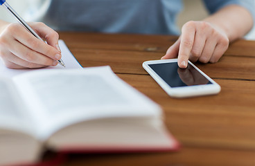 Image showing close up of student with smartphone and notebook