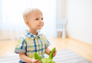 Image showing happy baby boy playing with ride-on toy at home