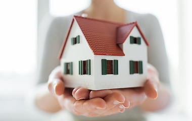 Image showing close up of hands holding house or home model