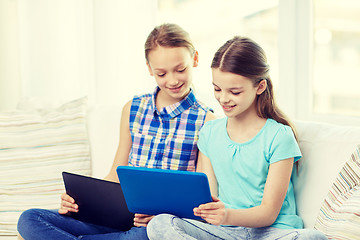 Image showing happy girls with tablet pc sitting on sofa at home