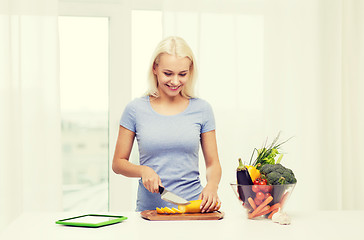 Image showing smiling young woman cooking vegetables at home