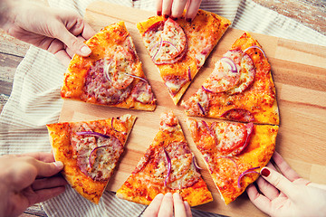 Image showing close up of hands and homemade pizza