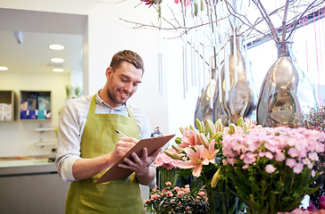 Image showing florist man with clipboard at flower shop