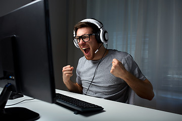 Image showing man in headset playing computer video game at home