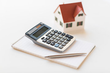 Image showing close up of home model, calculator and notebook