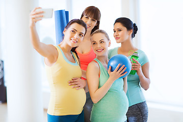 Image showing pregnant women taking selfie by smartphone in gym